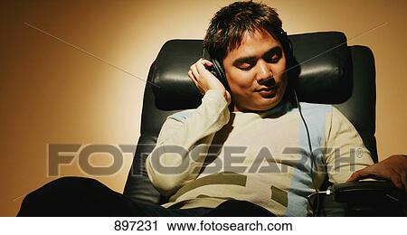 Stock Image - Listening to music on headphones. Fotosearch