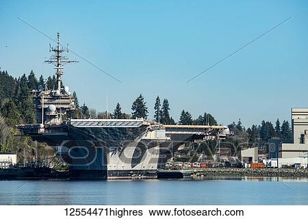 Stock Photograph - Looking straight on the bow of the USS Nimitz Air Craft Carrier moored in the Bremerton Shipyard. USS Nimitz is a supercarrier of the United States Navy, and the lead ship of her class. One of the largest warships in the world; Bremerton, Washington,.... Fotosearch