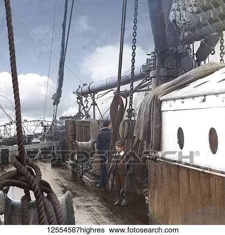 Stock Photograph - Magic lantern slide circa 1880, Victorian/Edwardian Social History. A hand-colourized image of a boy and man on board a whaling (whaler) ship.. Fotosearch