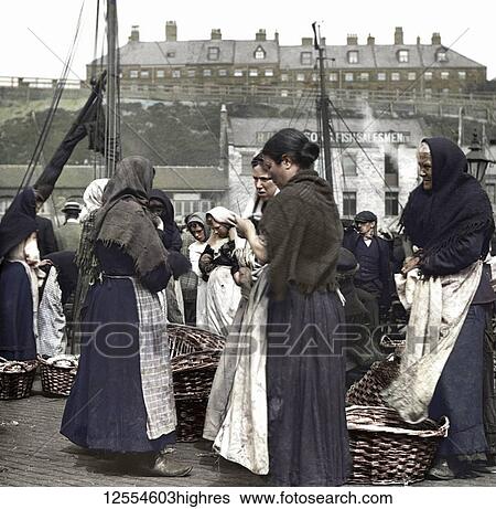 Stock Photograph - Magic Lantern Slide circa 1880, Victorian/Edwardian Social History. Fish women at North Shields Fish Quay with baskets of herring; North Shields, Tyne and Wear, England. Fotosearch