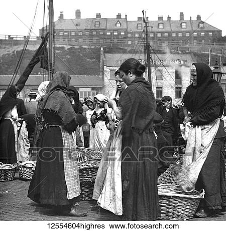Stock Photograph - Magic Lantern Slide circa 1880, Victorian/Edwardian Social History. Fish women at North Shields Fish Quay with baskets of herring; North Shields, Tyne and Wear, England. Fotosearch