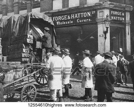 Stock Photograph - Magic lantern slide circa 1880, Victorian/Edwardian Social History. Forge and Hatton Limited, Billingsgate Market London. Loading fish onto horse and wagons for railway journey. Wholesale fish curer shop with fishmongers and straw hats; London, England. Fotosearch