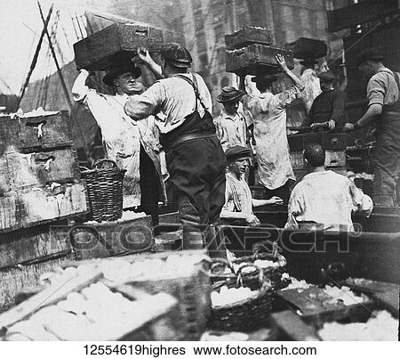 Stock Photograph - Magic lantern slide circa 1880, Victorian/Edwardian Social History. North Sea fishermen unloading and boxing fish on board fishing boat.. Fotosearch