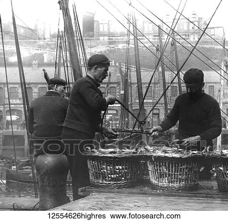 Stock Photograph - Magic lantern slide circa 1880., Victorian/Edwardian Social History. A picture of fishermen unloading herring at North Shields Fish Quay; North Shields, Tyne and Wear, England. Fotosearch