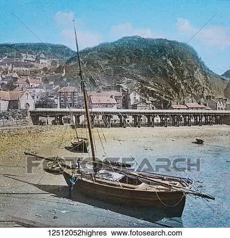 Magic Lantern slide circa 1887 hand coloured. created in 1887. Barnmouth from the Jetty. Barmouth (Welsh: Abermaw (formal); Y Bermo (colloquial)) is a town in the county of Gwynedd, north-western Wales, lying on the estuary of the River Mawddach and... View Large Photo Image Stock Photograph - Magic Lantern slide circa 1887 hand coloured. created in 1887. Barnmouth from the Jetty. Barmouth (Welsh: Abermaw (formal); Y Bermo (colloquial)) is a town in the county of Gwynedd, north-western Wales, lying on the estuary of the River Mawddach and.... Fotosearch