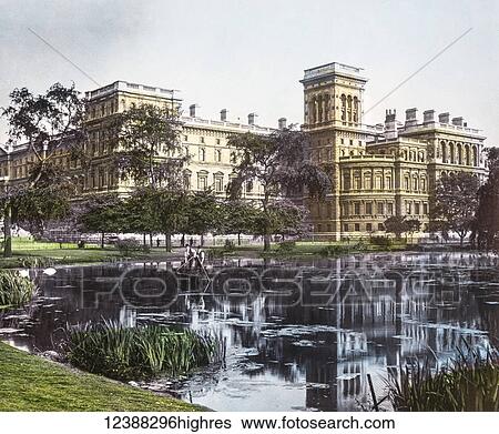 Stock Photograph - Magic Lantern slide circa 1900 hand coloured views of London, England in Victorian times. Government buildings from St James Park with pond in front. Maintenance men cleaning the pond. Fotosearch