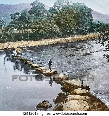 Stock Photograph - Magic Lantern slide circa 1900 hand coloured. created in 1887. A tour of North Wales. 11. Stepping-stones at Bettws-y-Coed. Returning to Bettws, say in the evening, we enjoy a good tea, and then, if fine, take a stroll across to the Conway by the.... Fotosearch