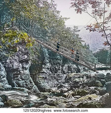 Stock Photograph - Magic Lantern slide circa 1900 hand coloured. created in 1887. A tour of North Wales. 12. Miners Bridge, over the Llugy. This pretty spot is about a mile up the Capel Curig road, where we turn aside on the right, and by following a footpath in the.... Fotosearch