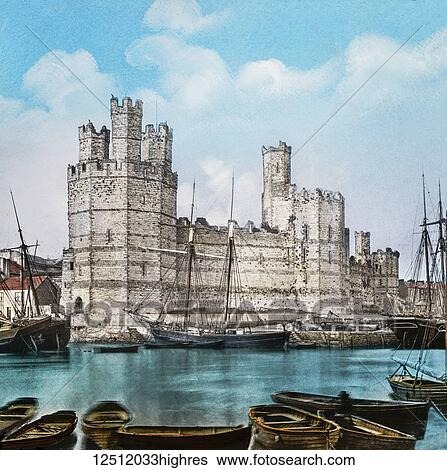 Stock Photograph - Magic Lantern slide circa 1900 hand coloured. created in 1887. Carnarvon, caenarfon, Castle, from the Ferry. This view is taken from the other side of the River Seoint, and gives one a fair idea of the grandeur of this noble building, which is one of the.... Fotosearch