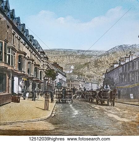 Stock Photograph - Magic Lantern slide circa 1900 hand coloured. created in 1887. A tour of North Wales. 3. LlandudnoMostyn Street. A walk through the town will convince the rambler that Llandudno was chiefly built for the convenience of visitors. Mostyn Street, a.... Fotosearch