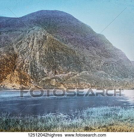 Magic Lantern slide circa 1900 hand coloured. created in 1887. A tour of North Wales. Lake Cwellyn, with Craig Cwra Bychan. The road passes along the Lakes margin, and this view is seen to the right. Llyn Cwellyn is nearly two miles in length, and is... View Large Photo Image Stock Photograph - Magic Lantern slide circa 1900 hand coloured. created in 1887. A tour of North Wales. Lake Cwellyn, with Craig Cwra Bychan. The road passes along the Lakes margin, and this view is seen to the right. Llyn Cwellyn is nearly two miles in length, and is.... Fotosearch