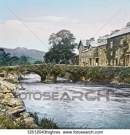 Magic Lantern slide circa 1900 hand coloured. created in 1887. A tour of North Wales. Beddgelert Bridge, Here we get a view of a portion of this very picturesque little village, with its ivy-covered bridge. Beddgelert is situated at the junction of... View Large Photo Image Stock Photograph - Magic Lantern slide circa 1900 hand coloured. created in 1887. A tour of North Wales. Beddgelert Bridge, Here we get a view of a portion of this very picturesque little village, with its ivy-covered bridge. Beddgelert is situated at the junction of.... Fotosearch