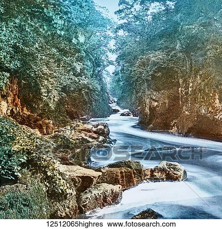 Magic Lantern slide circa 1900 hand coloured. created in 1887. A tour of North Wales. 9. The Fairy Glen, Bettws-y-Coed. This is truly an enchanting spot, and the tourist should spend a good quarter-of-an-hour in feasting his eyes on the beauty of the... View Large Photo Image Stock Photograph - Magic Lantern slide circa 1900 hand coloured. created in 1887. A tour of North Wales. 9. The Fairy Glen, Bettws-y-Coed. This is truly an enchanting spot, and the tourist should spend a good quarter-of-an-hour in feasting his eyes on the beauty of the.... Fotosearch