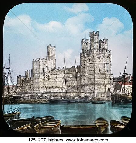 Stock Photograph - Magic Lantern slide circa 1900 hand coloured. created in 1887. Carnarvon, caenarfon, Castle, from the Ferry. This view is taken from the other side of the River Seoint, and gives one a fair idea of the grandeur of this noble building, which is one of the.... Fotosearch