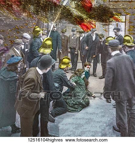 Stock Photograph - Magic Lantern slide circa 1900 hand coloured. Victorian/Edwardian era. Life models. Slide 18 of The fireman's wedding (recitation: Bamforth & Co., 21 slides, 1902). Fireman rcues a lady from a fire whilst a crowd look on. Fotosearch