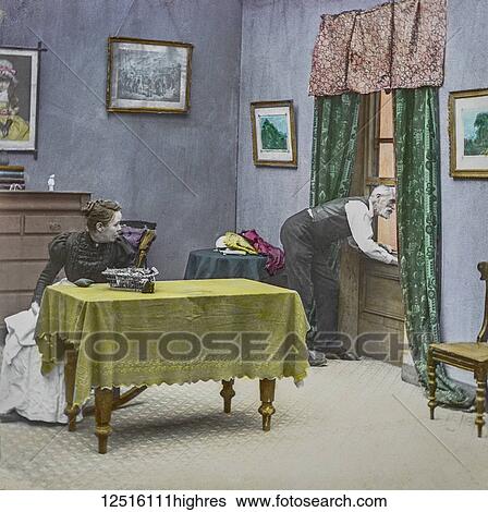 Magic Lantern slide circa 1900 hand coloured. Victorian/Edwardian era. Life models. Slide 4 of The fireman's wedding (recitation: Bamforth & Co., 21 slides, 1902). A man looking out of an open window with his wife sitting at the table View Large Photo Image Stock Photograph - Magic Lantern slide circa 1900 hand coloured. Victorian/Edwardian era. Life models. Slide 4 of The fireman's wedding (recitation: Bamforth & Co., 21 slides, 1902). A man looking out of an open window with his wife sitting at the table. Fotosearch