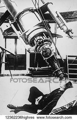 Stock Photograph - Magic lantern slide circa 1900. Victorian. A man looking through a large telescope in an observatory. Fotosearch