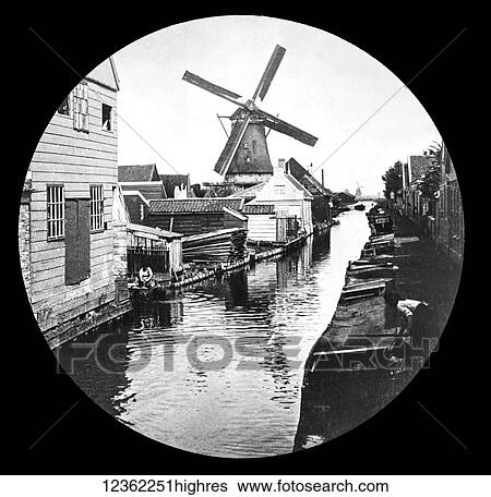 Stock Photograph - Magic lantern slide circa 1900. Victorian. A windmill on the river with old houses and work yards. Fotosearch