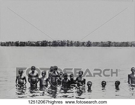 Stock Photograph - Magic lantern slide circa 1900. Victorian. Social History. Society for the propagation of the gospel in foreign parts. Missionary work in Madagascar off the coast of Africa. Choir boys bathing in the river. Fotosearch