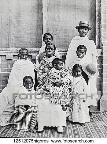 Stock Photograph - Magic lantern slide circa 1900. Victorian. Social History. Society for the propagation of the gospel in foreign parts. Missionary work in what is believed to be Couva Trinidad. The image showing a complete family protrait. Fotosearch