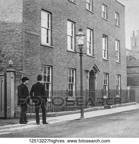 Stock Photograph - Magic lantern slide circa 1900. Victorian. Social History. Image from a slide presentation entitled In His step or In jesus Name. Two gentlemen walking in the street. Fotosearch