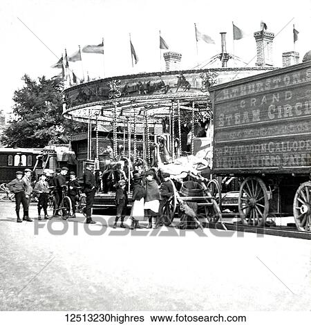 Stock Photograph - Magic lantern slide circa 1900. Victorian. Social History. Image from a slide presentation entitled In His step or In jesus Name. H. Thursons grand steam circus. Fairground ride with platform gallopes. children and people watching the ride with Royal.... Fotosearch