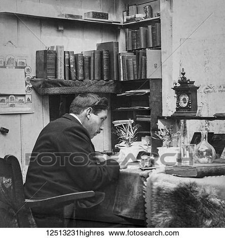 Stock Photograph - Magic lantern slide circa 1900. Victorian. Social History. Image from a slide presentation entitled In His step or In jesus Name. The reverend sitting at his desk writing his sermon. Fotosearch