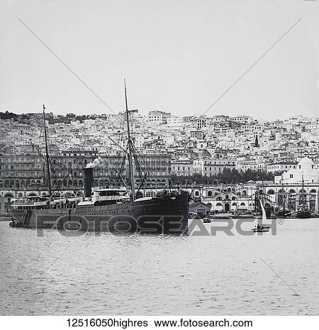 Stock Photograph - Magic lantern slide circa 1900. Victorian. Social History. No. 1. Algiers from the Harbour. Of all towns op the Mediterranean between Tunis and Tangiers there is none so calculated to enchant the traveller upon a first view as Algiers, both on account of.... Fotosearch