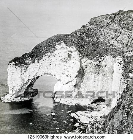 Stock Photograph - Magic lantern slide circa 1900. Victorian/Edwardian. Social History. Limestone arch, the White Cliffs northern coast County Antrim. Fotosearch