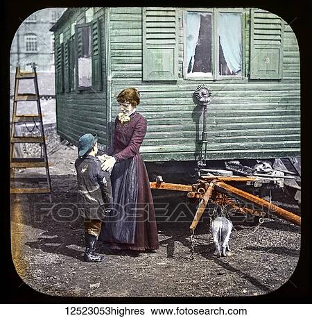 Stock Photograph - Magic lantern slide circa 1900. Victorian/Edwardian. Social History. Mrs Isabel Reaney story of Willie Wills Wings and slide show a christian story. Life model painted background. Slide 10 'Mother, I've got a customer for a comb'. A boy wroking for.... Fotosearch