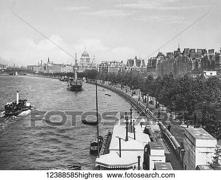 Stock Photograph - Magic Lantern slide circa 1900 views of London, England in Victorian times. Looking along the Victoria Embankment towards St Pauls Cathedral. Pleasure paddle steamer on the Thames with sailing ships and small boats.. Fotosearch