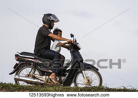 Man and boy on a motorcycle by the Tonle Sap; Siem Reap, Cambodia View Large Photo Image Stock Photograph - Man and boy on a motorcycle by the Tonle Sap; Siem Reap, Cambodia. Fotosearch