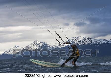Stock Photograph - Man kitesurfing in Kachemak Bay, South-central Alaska; Alaska, United States of America. Fotosearch