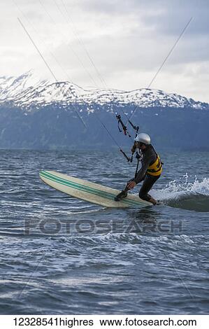 Stock Photograph - Man kitesurfing in Kachemak Bay, South-central Alaska; Alaska, United States of America. Fotosearch