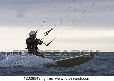 Stock Photograph - Man kitesurfing in Kachemak Bay, South-central Alaska; Alaska, United States of America. Fotosearch