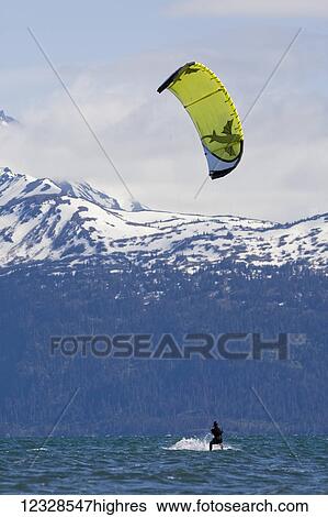 Stock Photograph - Man kitesurfing in Kachemak Bay, South-central Alaska; Alaska, United States of America. Fotosearch