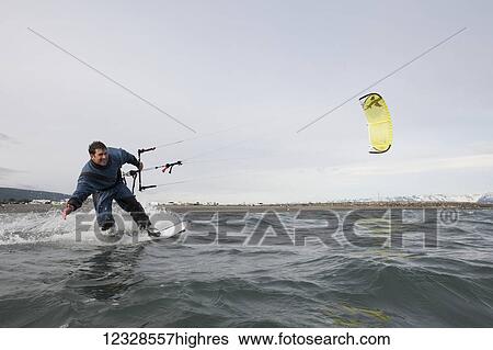 Stock Photograph - Man kitesurfing in Kachemak Bay, South-central Alaska; Homer, Alaska, United States of America. Fotosearch