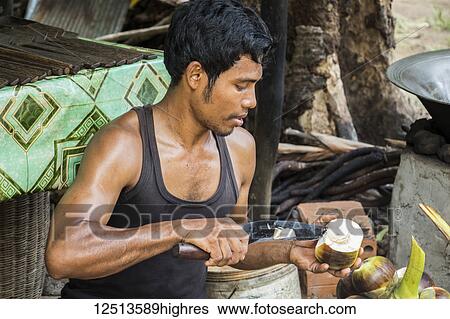 Stock Photograph - Man preparing palm sugar in a village near Siem Reap; Siem Reap, Cambodia. Fotosearch