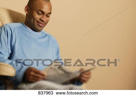 Stock Image - Man reading magazine. Fotosearch