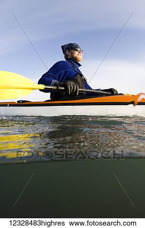 Stock Photograph - Man sea kayaking in Kachemak Bay, South-central Alaska; Homer, Alaska, United States of America. Fotosearch