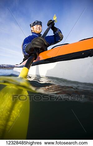 Stock Photograph - Man sea kayaking in Kachemak Bay, South-central Alaska; Homer, Alaska, United States of America. Fotosearch