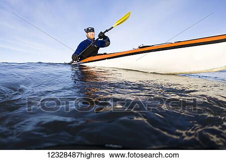 Stock Photograph - Man sea kayaking in Kachemak Bay, South-central Alaska; Homer, Alaska, United States of America. Fotosearch