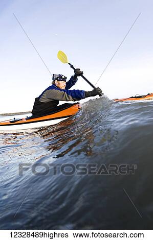 Stock Photograph - Man sea kayaking in Kachemak Bay, South-central Alaska; Homer, Alaska, United States of America. Fotosearch