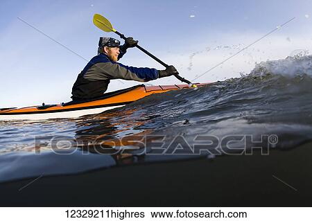 Stock Photograph - Man sea kayaking near Homer, South-central Alaska; Alaska, United States of America. Fotosearch