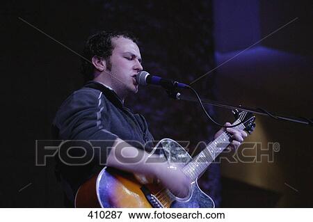 Stock Photo - Man singing and playing guitar. Fotosearch