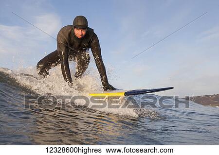 Stock Photograph - Man surfing, South-central Alaska; Homer, Alaska, United States of America. Fotosearch
