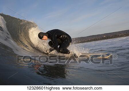 Stock Photograph - Man surfing, South-central Alaska; Homer, Alaska, United States of America. Fotosearch