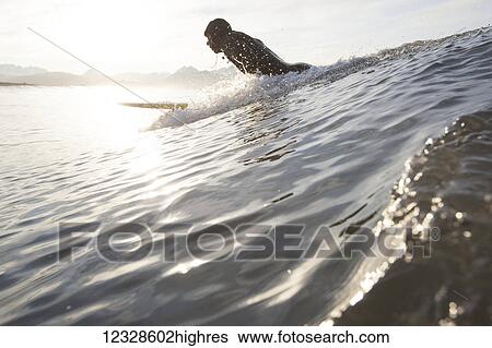 Stock Photograph - Man surfing, South-central Alaska; Homer, Alaska, United States of America. Fotosearch