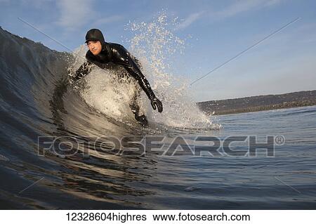 Stock Photograph - Man surfing, South-central Alaska; Homer, Alaska, United States of America. Fotosearch