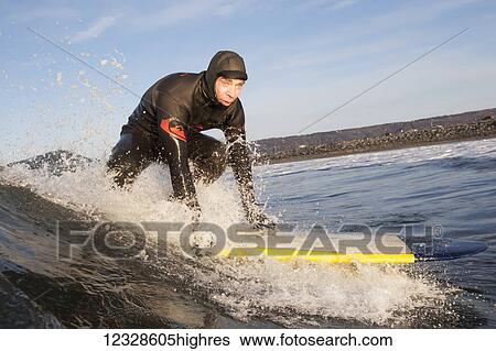 Stock Photograph - Man surfing, South-central Alaska; Homer, Alaska, United States of America. Fotosearch